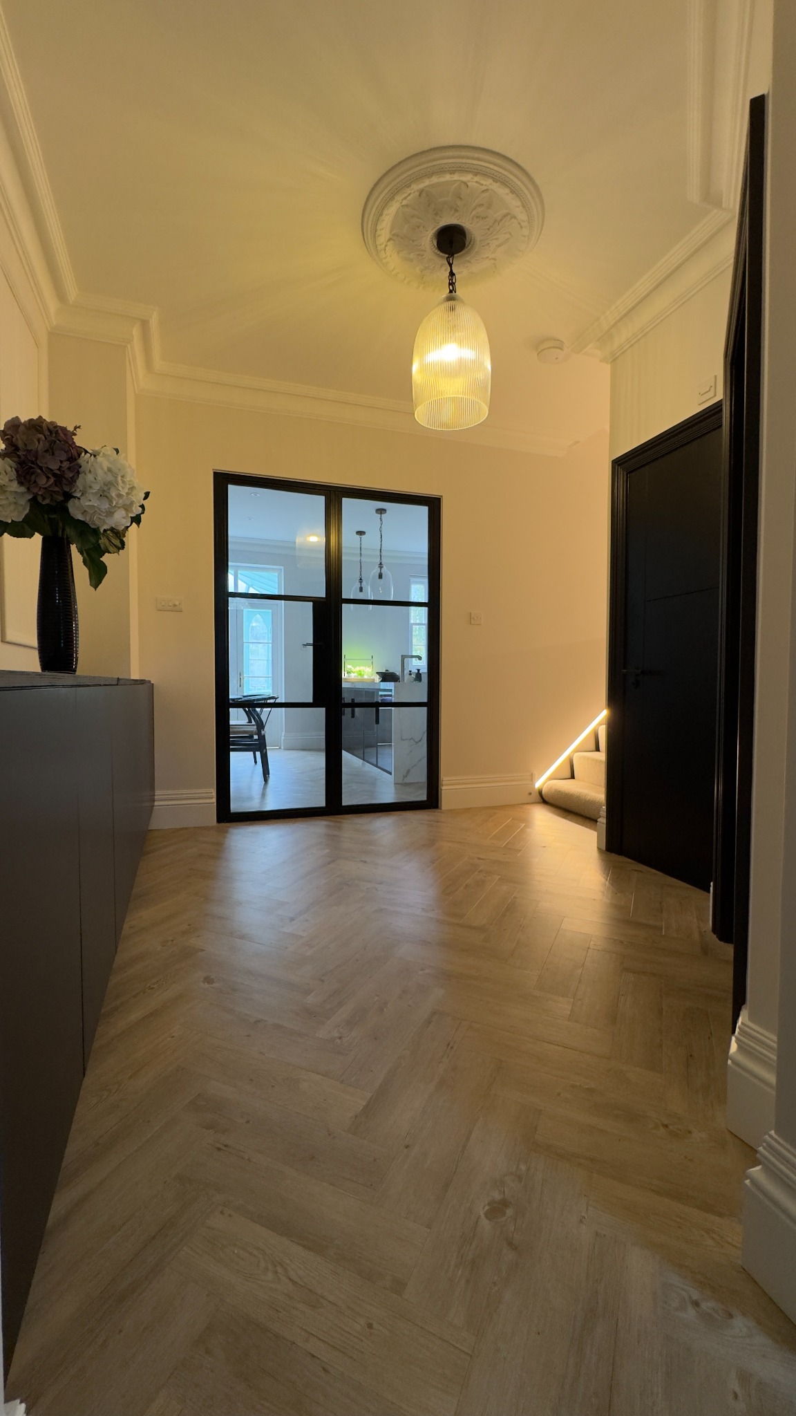 Warm oak herringbone LVT flooring in a completed interior